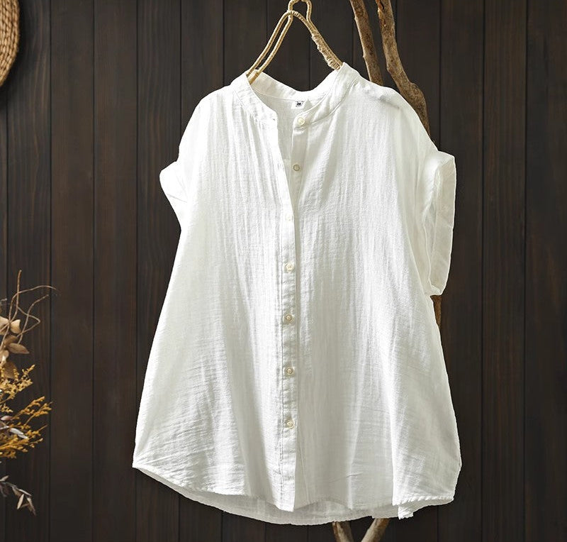 White sleeveless shirt hanging on a wooden hook against a dark wooden background