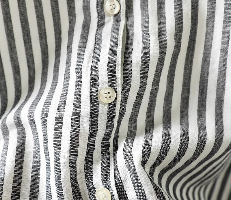 Close-up of a black and white striped shirt with buttons.