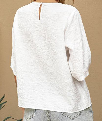 White long-sleeve top worn by a person on a beige background