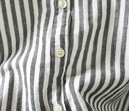 Close-up of a black and white striped shirt with buttons.